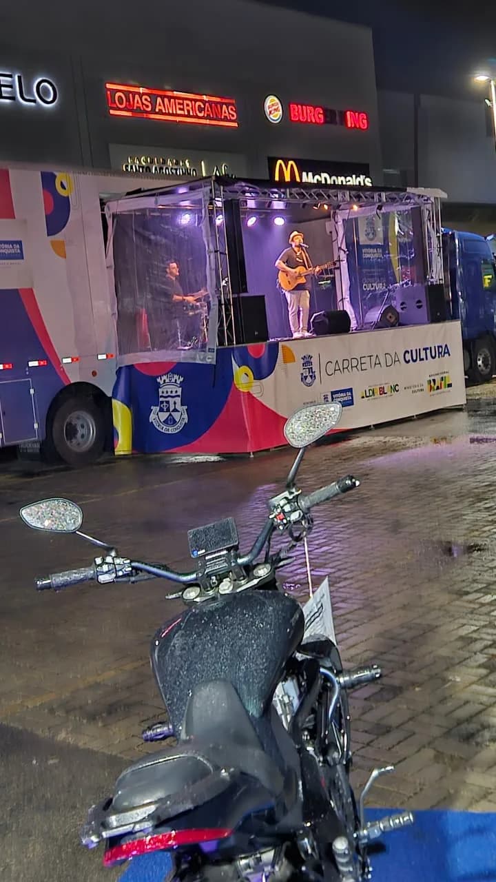 Show na Carreta da Cultura, à noite, com uma moto da Urbanu's em primeiro plano