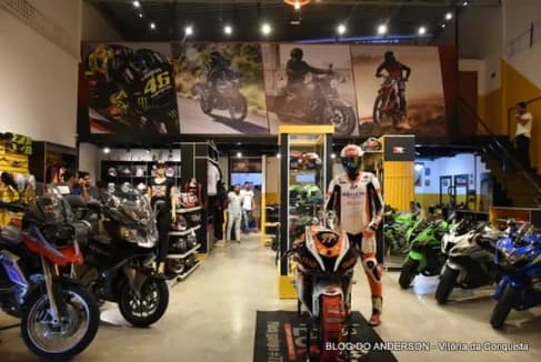 Salão da Urbanu's antes de se tornar concessionária Suzuki, com motos expostas, capacetes e vitrines de acessórios